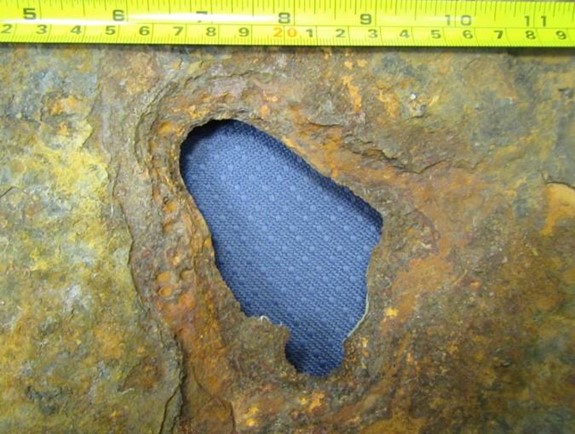 A 100-by-100 mm hole was observed when layers of metal were removed from the sample’s soil side.
