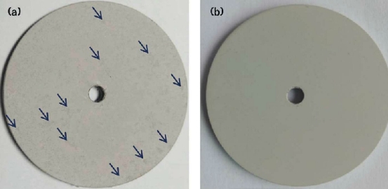 FIGURE 4 The appearance of MAO coatings formed in (a) additive-free and (b) 7 g/L additive-containing electrolyte after a salt solution immersion test in 5 wt% NaCl solution for 96 h. The coating formed in the additive-free electrolyte showed some scattered black areas (marked by the blue arrows).