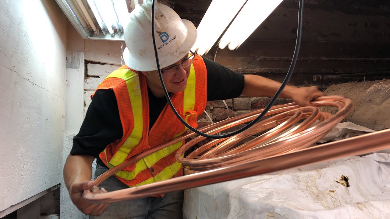 A worker holds a replacement copper water line. Photo courtesy of Denver Water.
