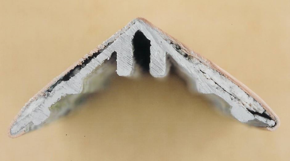 FIGURE 2 Cross-section through a “dress cap”. The aluminum angle is clad with copper sheet. Note: white corrosion product (aluminum hydroxide) on the angle.