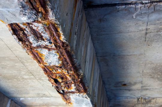 Close-up of a corroded bridge support beam.
