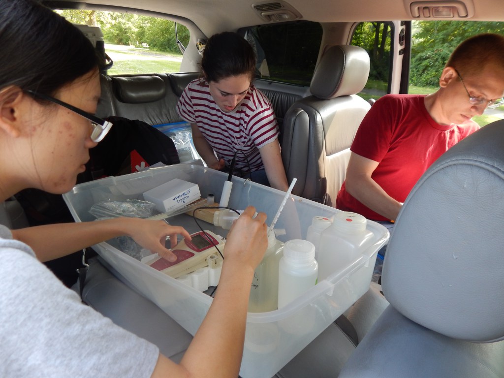 Min Tang, Bekah Martin, and Otto Schwake process chemical samples and take measurements in their mobile lab in Flint, Michigan. Photo credit: Flintwaterstudy.org.
