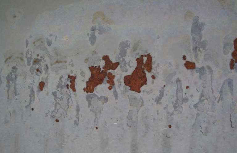 Figure 1: Spot rusting and blistering on a water-borne IOZ silicate coating due to alkali production from condensation during curing.  